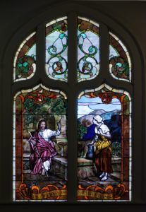 Stained glass window of Jesus at the well with Samaritan woman. Inscribed with In Memory of Mrs. Mary A. Turner.